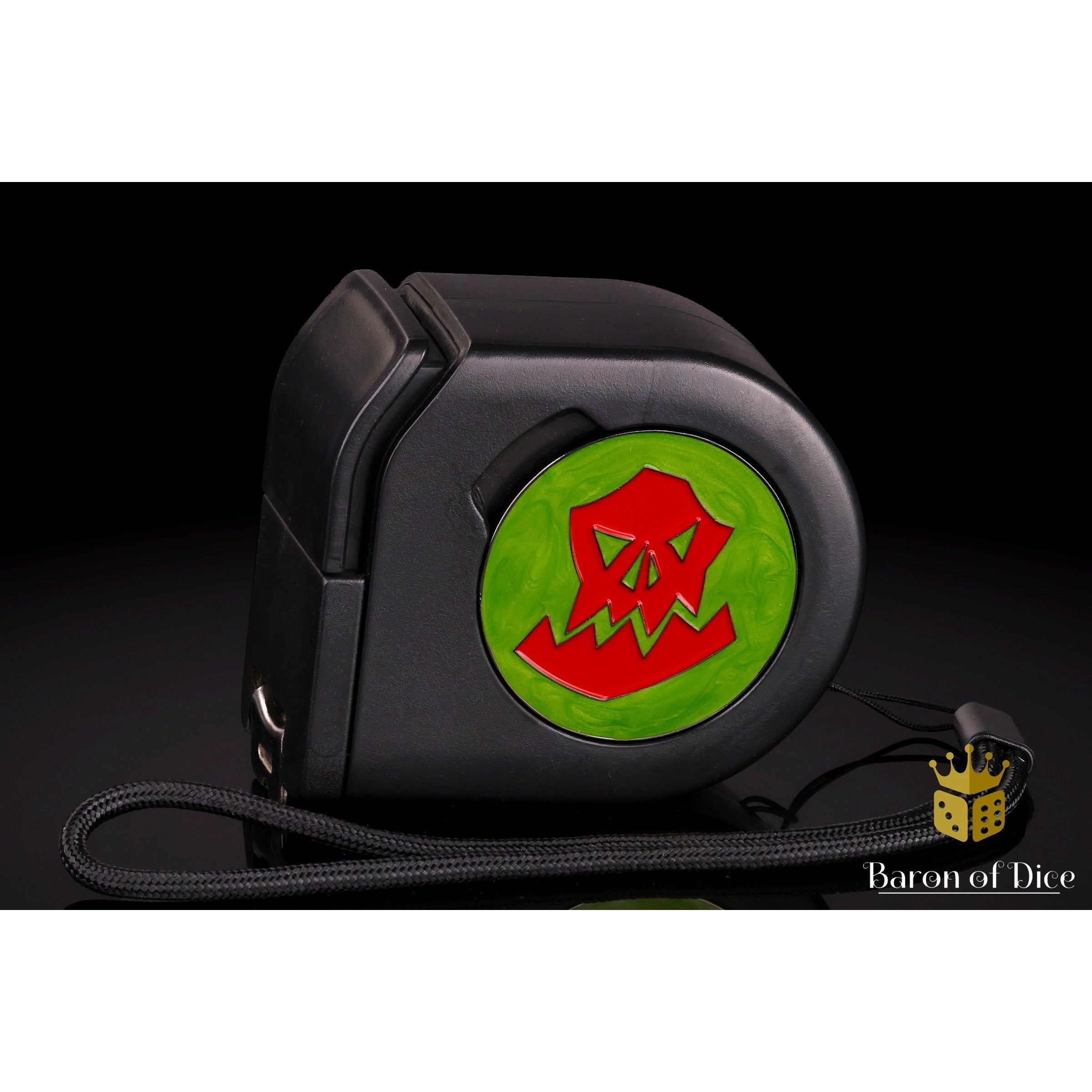 Wargaming Tape Measure by Baron of Dice — black tape with imperial and metric markings and a magnetic 40mm Baron's Coin slot