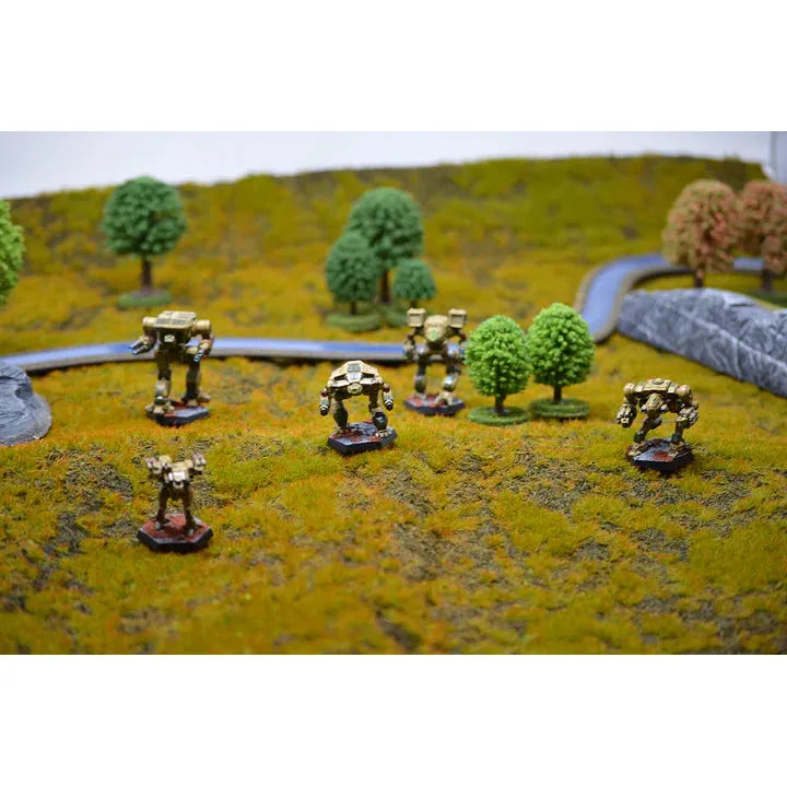 BattleTech: Alpha Strike miniatures on a tabletop battlefield diorama with trees and terrain.