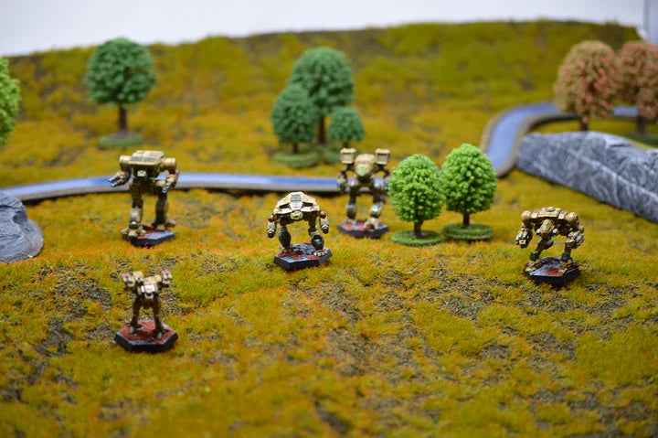 BattleTech: Alpha Strike miniatures on a tabletop battlefield diorama with trees and terrain.